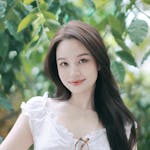 Charming portrait of a young woman outdoors in Ho Chi Minh City, surrounded by lush greenery.